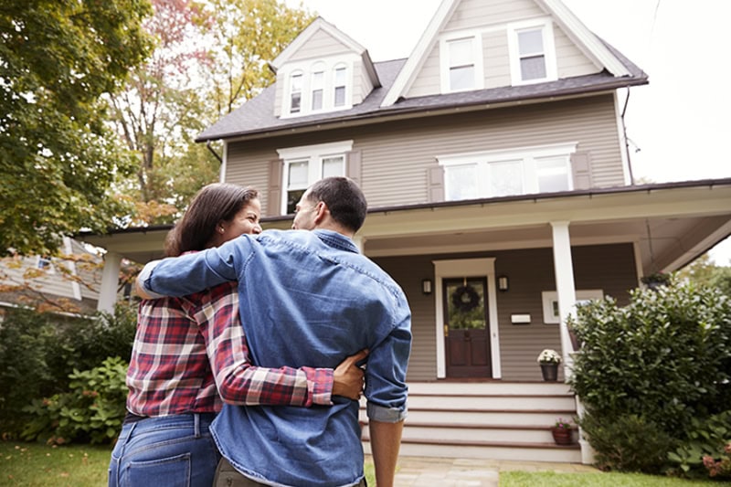 Rear View Of Loving Couple Walking Towards House.